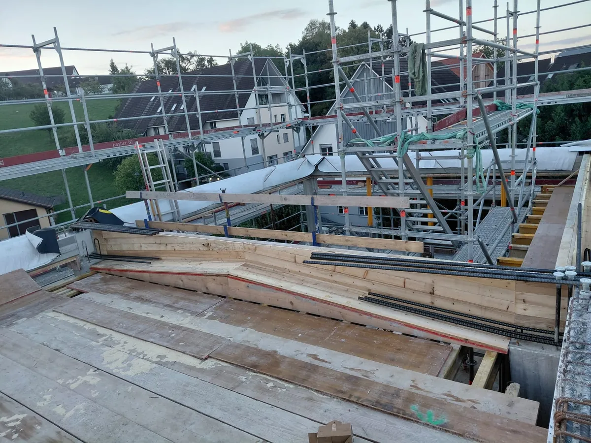 Eingeschalter Dachrand mit Anschlusseisen und Gerüst über den Nachbardächern