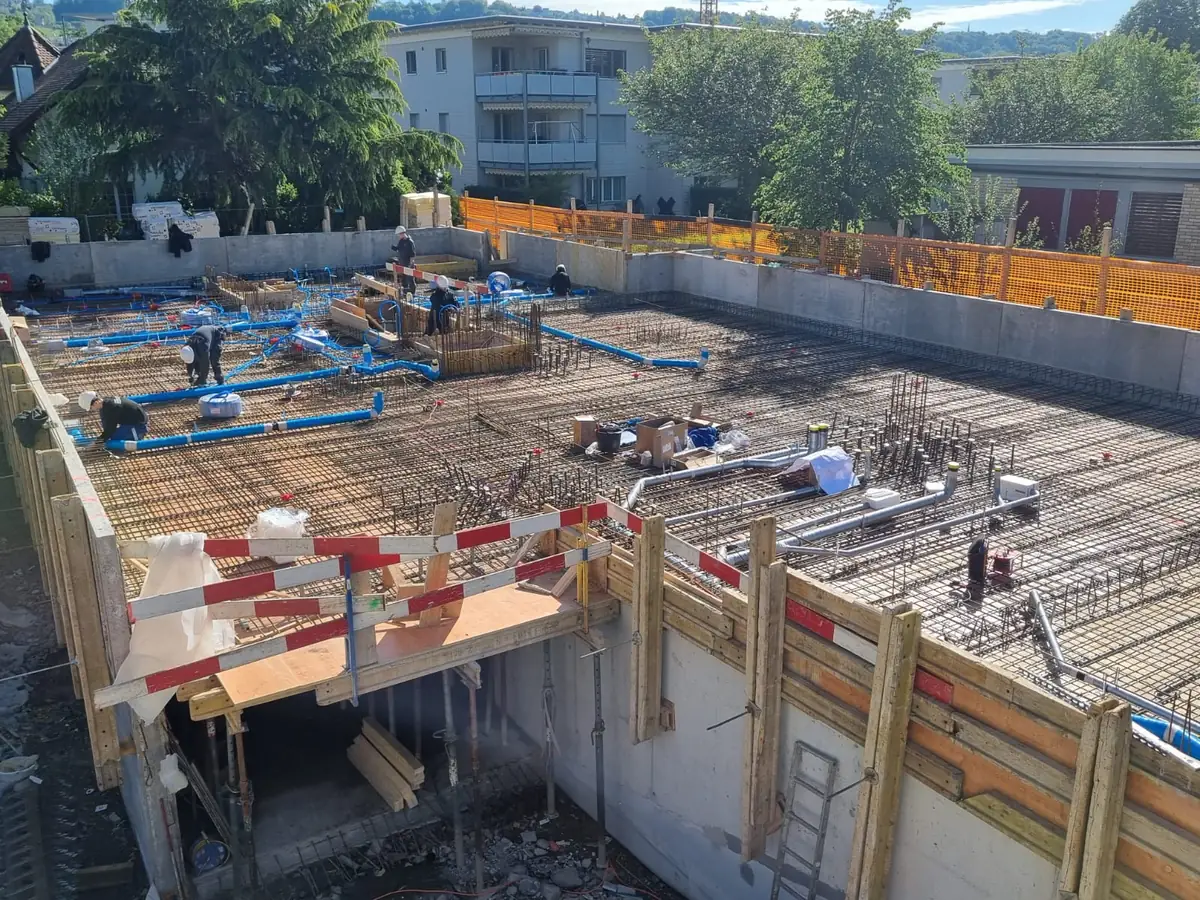 Armierer verlegen die Bewehrung einer Geschossdecke über dem eingeschalten Untergeschoss