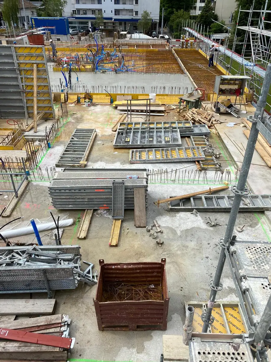 Sortiert gestapelte Schalungstafeln und Träger auf dem Materialplatz der Baustelle