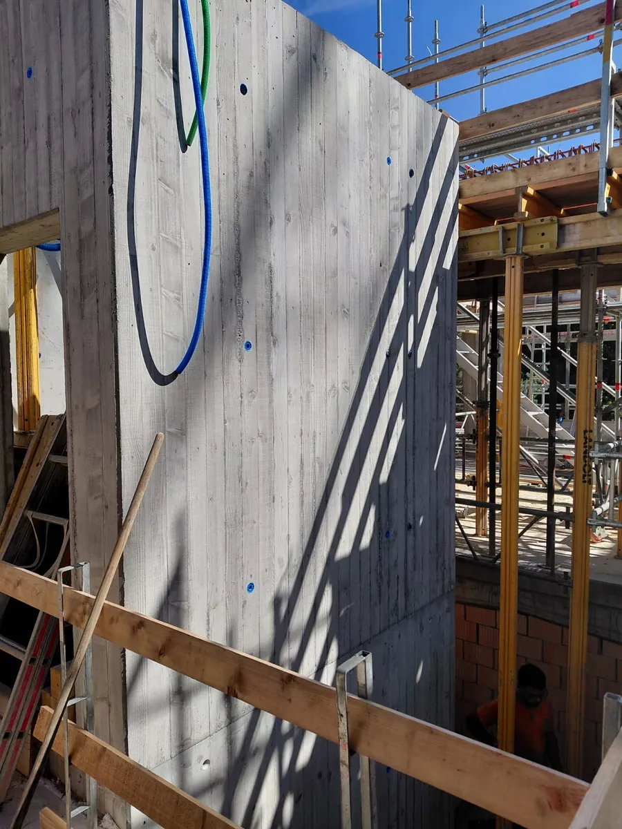 Sichtbetonwand in Brettschalung mit sichtbarer Holzmaserung und Ankerstellen